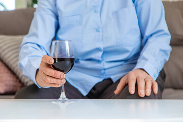 Old woman drinking wine. Selective focus.