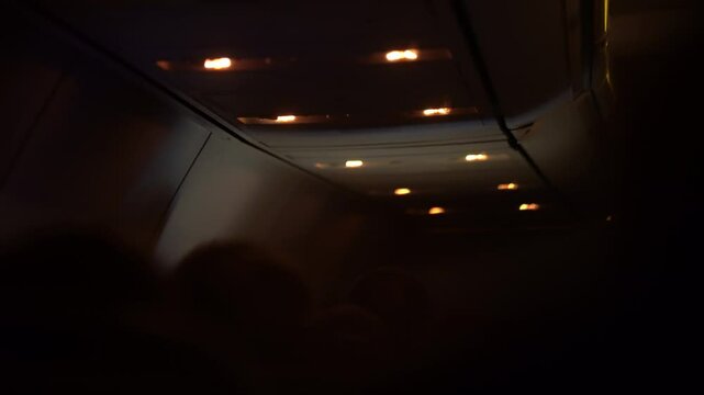 Lights, overhead airplane cabin view with ceiling panels and control buttons visible. High quality 4k footage