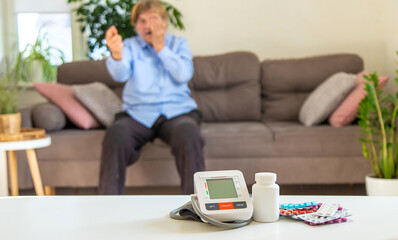 An old woman measures her blood pressure. Selective focus.