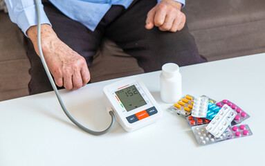 An old woman measures her blood pressure. Selective focus.
