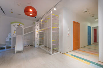 Playground in a modern kindergarten. A complex with a slide, ropes and climbing ladders.