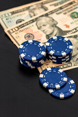Stacks of poker chips with money on black background