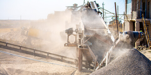 Vibrating screen stone crusher in operation. Crushing stones in a quarry for processing minerals,...