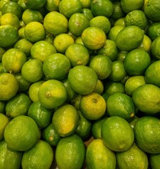 Fresh green lemons on display in bulk