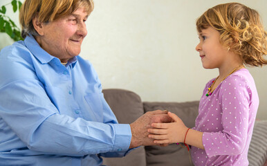 Fototapeta premium Old woman with her granddaughter. Selective focus.