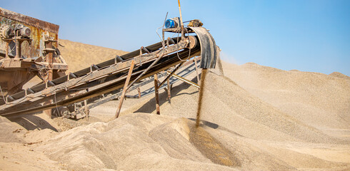 Crushing stones in a quarry for processing minerals, cement, limestone. Distribution and Screening Plant Gravel. Vibrating screen stone crusher in operation.