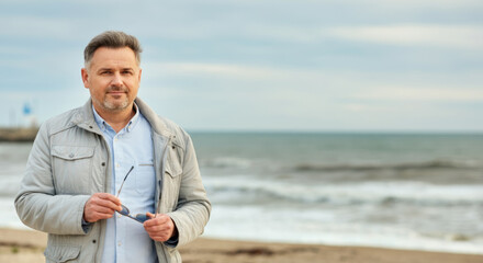 Mature caucasian male enjoying a breezy day at the beach
