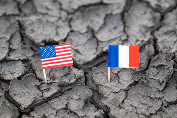 Flag of USA and France on cracked soil. Concept of problems in relations between countries,...