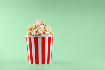Classic red striped popcorn cardboard cup on Green background