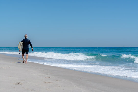 surfer walking on beach