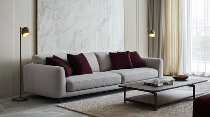 A minimalist living room with a soft gray sofa paired with rich maroon pillows and a dark wood coffee table