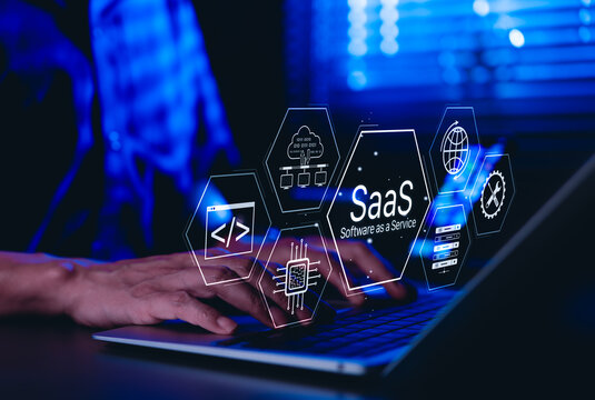 SaaS Software as a Service Concept. Man using laptop with futuristic interface SaaS (Software as a Service) icons, cloud computing, solutions, software development elements, modern technology platform - Powered by Adobe