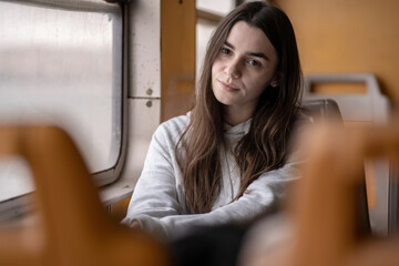 Thoughtful Young Caucasian Woman Looking Through Train Window Wearing Casual Sweatshirt. Lisbon,...