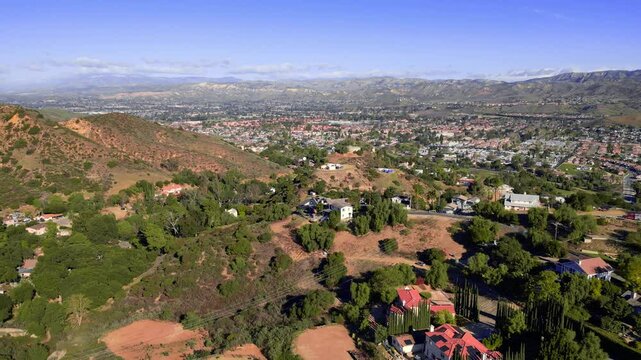 Aerial moving right over the Santa Susana Knolls area and revealing a view of suburban city of Simi Valley in Ventura County, California.