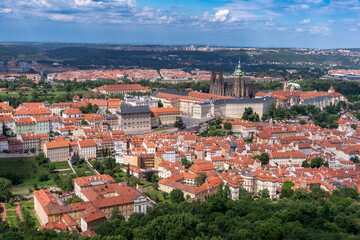 Fototapeta premium Panoramic view of Prague with the Vltava River, historic bridges, and red rooftops, surrounded by lush greenery. Stunning European cityscape showcasing Czech Republic’s architectural and natural beaut