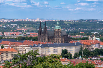 Panoramic view of Prague with the Vltava River, historic bridges, and red rooftops, surrounded by lush greenery. Stunning European cityscape showcasing Czech Republic’s architectural and natural beaut