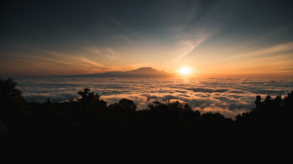 Sun rising over kilimanjaro, tanzania, creating a sea of clouds at dawn