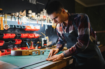 Portrait of handsome tanner man at work, small business, authentic workshop, indoors. leather goods.