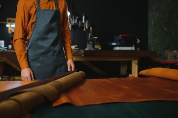 Man in a studio creates leather ware
