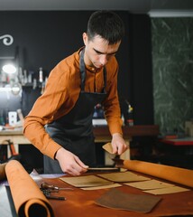 professional crafter checking the material at workplace,artisan checks the quality of a roll of...