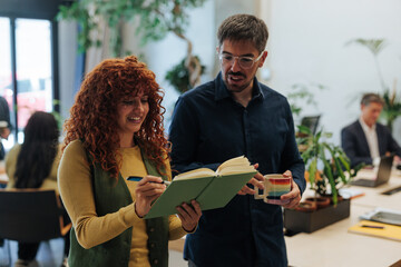 Colleagues collaborating, sharing ideas and taking notes in modern office