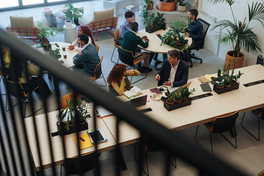 Coworkers collaborating in modern green office space