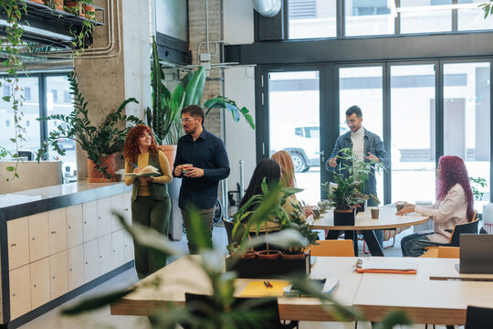 Coworkers collaborating in modern green office space