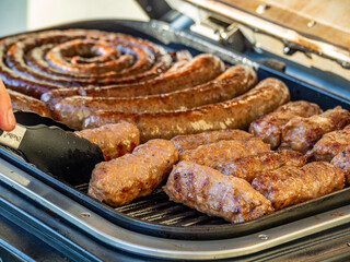 a closeup shot of sausages on a tray in a barbecue