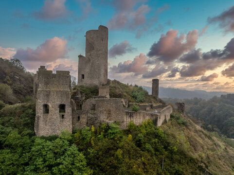 Aerial view of Philippsburg castle above Monreal in Germany with tall keep sunset sky