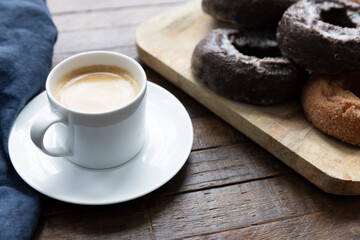 An Espresso and Chocolate Donuts on a Breakfast Table