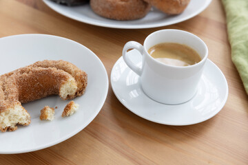 Cup of Espresso and Partialy Eaten Donut on a Breakfast Table