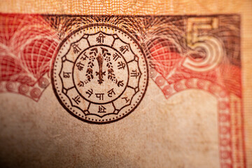 A macro shot of a Nepalese Rupee 5 banknote displaying an intricate engraving of two yaks in a mountainous landscape. The note's texture, design, and details are visible.