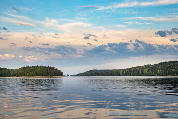 A calm lake with a few trees in the background