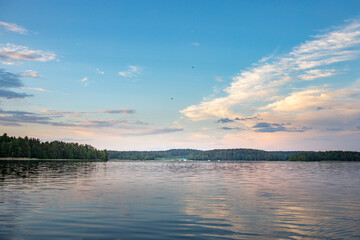 A lake with a cloudy sky in the background