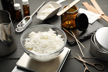 Soy wax, essential oils and different tools for making candles on grey wooden table, closeup