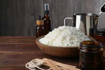 Soy wax and other supplies for making candles on wooden table, closeup