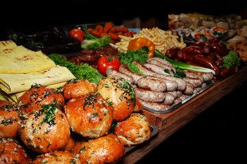 Varied assortment of hot ready-made dishes cooked on the grill. Selling food products at a street fair. Street food to go. Fast food.	