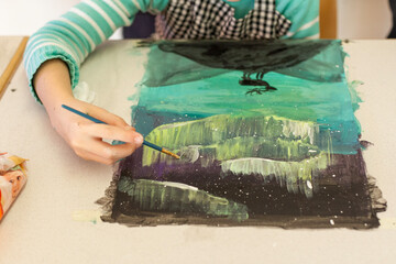 Painting activity of children with paintbrush and aquarelle in classroom