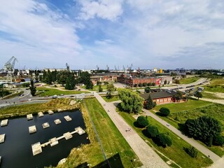 Aerial view of the Gdańsk Shipyard, Poland, showcasing historic industrial buildings, shipyard cranes, and a green urban landscape. A place of rich history and maritime heritage.