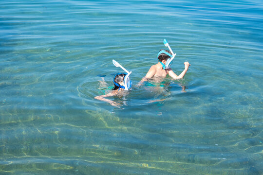 Two young children, siblings snorkeling together in sea, ocean waves on sunny summer day, family Water activities, Summer adventures foster curiosity and love for environment in kids