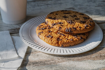 Homemade giant cookie with chocolate chips for breakfast in the rays of morning sunlight – a symbol of a warm family morning.