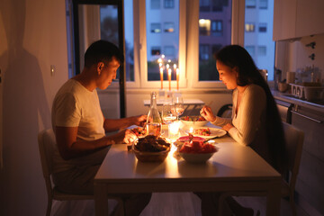 Couple enjoying romantic candlelit dinner at home