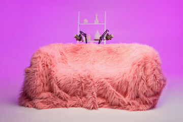 Cozy podcast setup with pink furry couch and unique decorations for a creative recording environment
