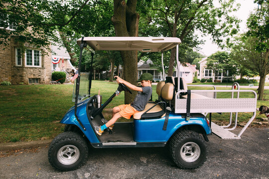 Boy Pretendting to drive a golf-cart 