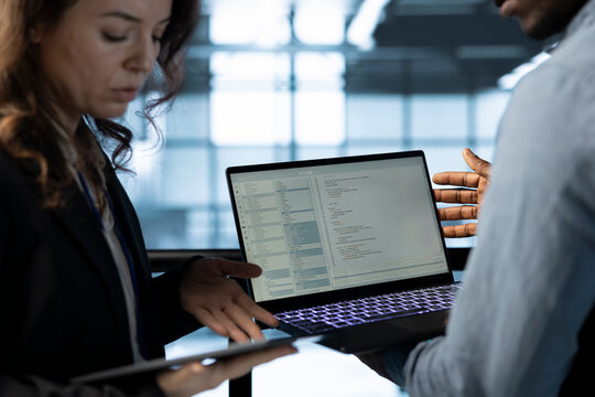 Software developers in data center workspace use laptop to calibrate energy usage. Server room IT professionals code on notebook, doing maintenance on equipment mainframes - Powered by Adobe