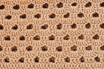 Handmade crochet knitted fabric, knitted pattern, craft wallpaper background . Handmade crochet fabric with intricate openwork pattern. Natural and textured background