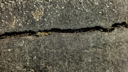 close-up of a crack in the pavement or road. dividing or fault line background. space for copy. full frame abstract backdrop design element.