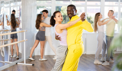Adult man and adult woman dance ballroom dance waltz in studio