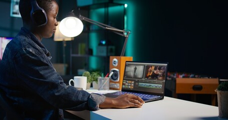 Close up on video editor putting headphones on in order to polish raw footage and improve audio...
