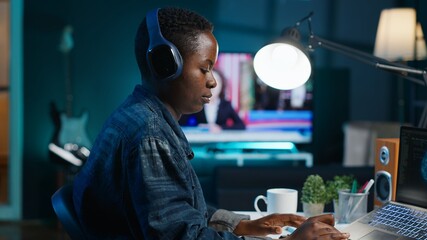 Programmer in living room office typing on keyboard, updating artificial intelligence neural...